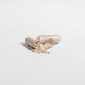 Two open capsules with a powdery substance on a light gray background