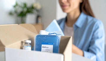Person opening a box with a blue container labeled 'Glovetech' and a vial.